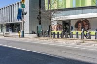 a city street has many bicycles chained to it and stores and businesses on the sides