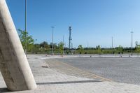 parking lot with a concrete pole and a cell phone in it's corner on an empty pavement