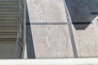 two people are riding skate boards on a path behind a building that has a clock