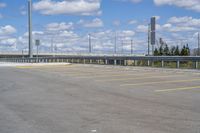 a parking lot with no vehicles parked next to it and an overpass at the top of the road