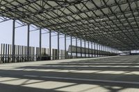 large air port filled with lots of metal structures and walkways with empty space for cars