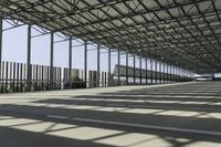 large air port filled with lots of metal structures and walkways with empty space for cars