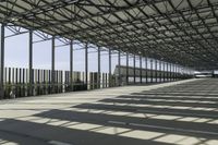 large air port filled with lots of metal structures and walkways with empty space for cars