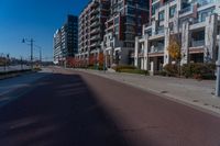 empty city street with two tall apartment buildings in the background on an autumn day's day