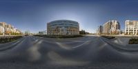 a panoramic photo of a city street intersection with buildings and a curved street