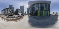 a fish eye view of cars parked on a city street next to tall buildings and a sidewalk