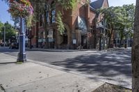 city street with traffic at an intersection and tall red brick building in the background with many windows