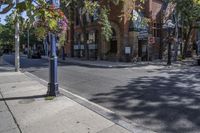 city street with traffic at an intersection and tall red brick building in the background with many windows