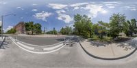 a 360 - shot of a street in the city has trees and a building in the background