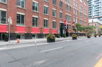 a bike is parked next to a street lined with tall red buildings and windows and a traffic signal