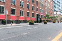 a bike is parked next to a street lined with tall red buildings and windows and a traffic signal