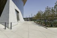 the sidewalk is lined with planter boxes, shrubs and walkways in front of the building