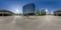 a panorama lens of some buildings and trees in an empty area of the city with no people