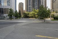 an empty, bricked road with lots of tall buildings and trees on the other side