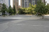 an empty, bricked road with lots of tall buildings and trees on the other side