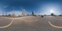 a panoramic image of several car parking lots and buildings with sun in back