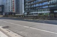 a empty road with multiple skyscrapers in the background and there is an empty street to the right of it