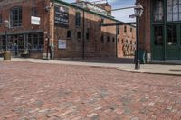 a brick paved street with a clock in front of a building and a sign saying the museum of stone