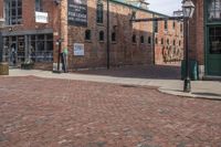 a brick paved street with a clock in front of a building and a sign saying the museum of stone