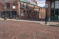 a brick paved street with a clock in front of a building and a sign saying the museum of stone