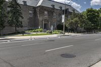 a city street with two stone buildings next to it and a stop sign in front