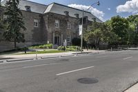 a city street with two stone buildings next to it and a stop sign in front