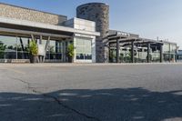 the exterior of an airport with large windows and a fire hydrant in the parking lot