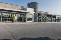 the exterior of an airport with large windows and a fire hydrant in the parking lot