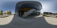 a fish eye lens image of a building with circular shapes on the roof and a curved facade