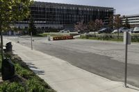 an empty parking lot in front of a building with lots of traffic signs and other signs