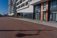 a black stop sign in the middle of the street in front of a high rise apartment building