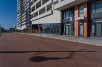 a black stop sign in the middle of the street in front of a high rise apartment building