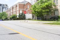 a stop sign at an intersection of an empty street next to some high rise buildings