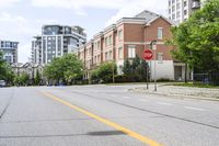 a stop sign at an intersection of an empty street next to some high rise buildings