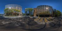 an urban looking picture of two buildings in the distance, as seen from below a spherical fish eye lens