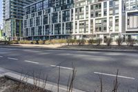 the buildings are on either side of a road with trees in the street between them