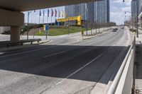 a highway with no cars on it and flags lining the other side of the road