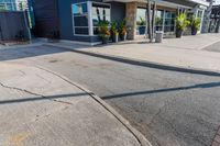 the entrance to a motel with red brick sidewalk and large windows, and landscaping on the side