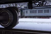 a close up of an abandoned train car on snow covered tracks in a country setting