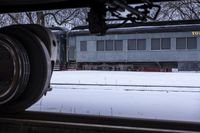 a close up of an abandoned train car on snow covered tracks in a country setting