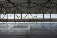 empty empty concrete space with metal ceiling and windows in the airy interior of an industrial building