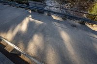 a bench sits beside a large river, and a wooden deck is overlooking the forest