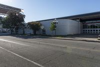 a building sits next to an intersection with two buildings that are under the shade of a sun - filled blue sky