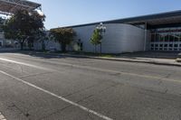 a building sits next to an intersection with two buildings that are under the shade of a sun - filled blue sky