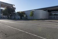 a building sits next to an intersection with two buildings that are under the shade of a sun - filled blue sky