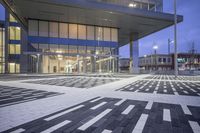 a modern building with glass doors and windows on it's exterior, as well as a black and white geometric pattern