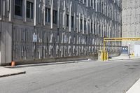 a parking meter sitting at the side of a street in front of a building with metal screens