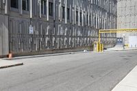 a parking meter sitting at the side of a street in front of a building with metal screens