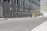 a parking meter sitting at the side of a street in front of a building with metal screens