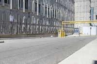 a parking meter sitting at the side of a street in front of a building with metal screens